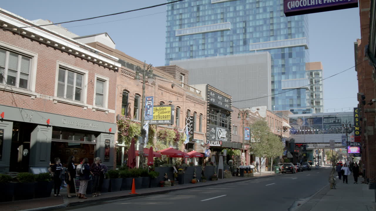 Wide shot pan in slow motion of Greektown Historic District with people in Detroit, Michigan.