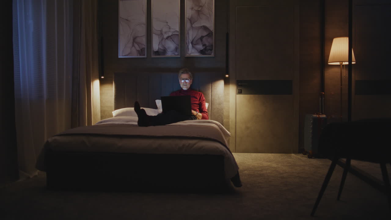 Man working on laptop in hotel room