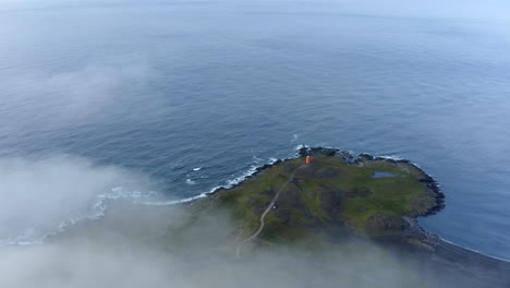 drone aerial footage of drone panning down through clouds to a icelandic peninsula in eastern iceland