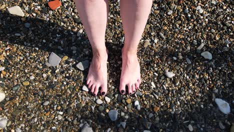 woman's feet on a pebble beach