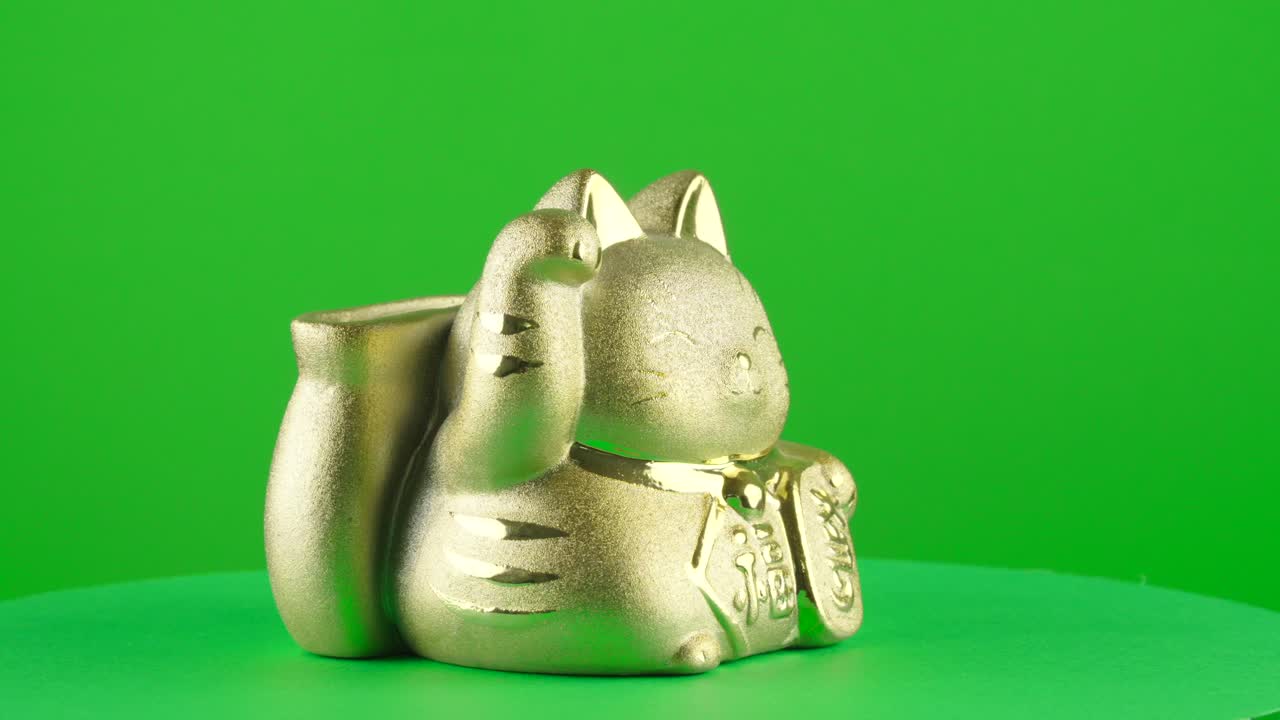 oro maneki neko caja de monedas puerco banco gato japonés afortunado en fondo verde chroma clave de reemplazo de fondo telón de fondo objeto en un tocadiscos 3d bucle giratorio