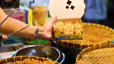 vendor packs fried bananas into a box