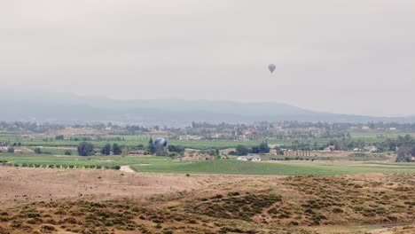 Globo-De-Temecula-Y-Festival-Del-Vino-Dos-Globos-Mientras-El-Dron-Vuela-De-Lado-De-Derecha-A-Izquierda