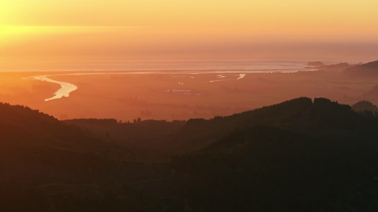 Golden California sunset over serene coastal hills and reflective waters