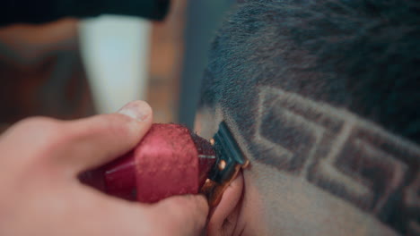 4k slow motion shot of a long shot of a haircut by a professional barber in a barbershop with a shave to a young man