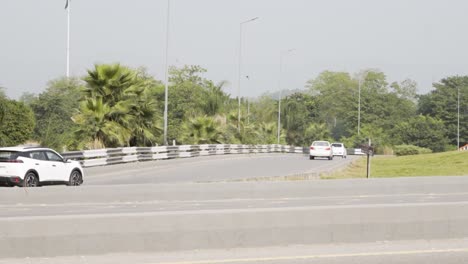 cars driving on a highway with palm trees