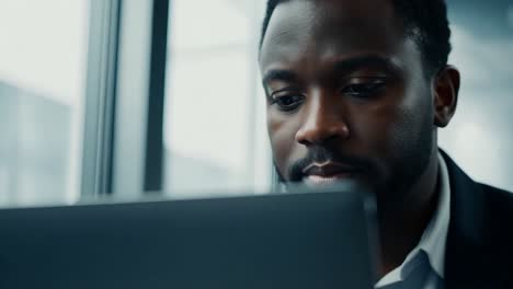 black businessman working on laptop in office