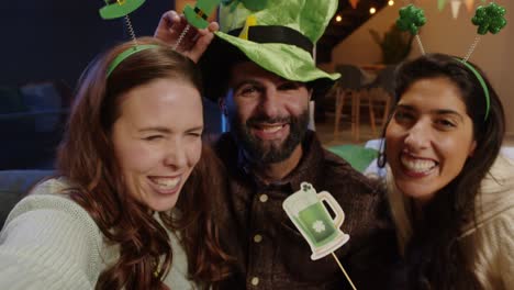 Toma-Pov-De-Amigos-Disfrazados-Con-Novedades-Y-Accesorios-Irlandeses-En-Casa-O-En-Un-Bar-Posando-Para-Una-Selfie-Celebrando-En-La-Fiesta-Del-Día-De-San-Patricio-En-Tiempo-Real-2