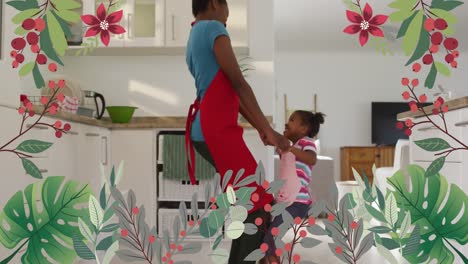 animation of plants and flowers over happy african american mother and daughter dancing in kitchen