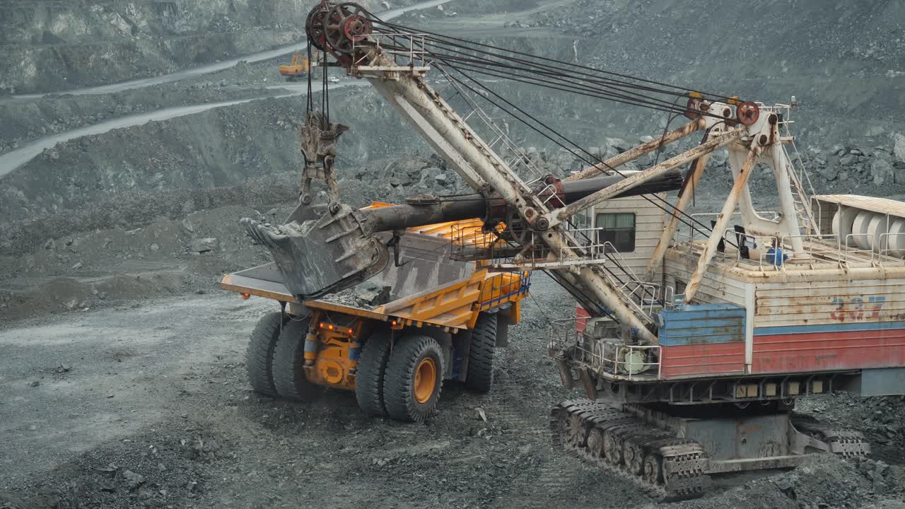 큰 광산 장비 는 광산 에서 광석 을 덤프 트럭 에 탑재 하고 있다