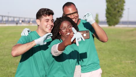 happy volunteers taking selfie with smartphone