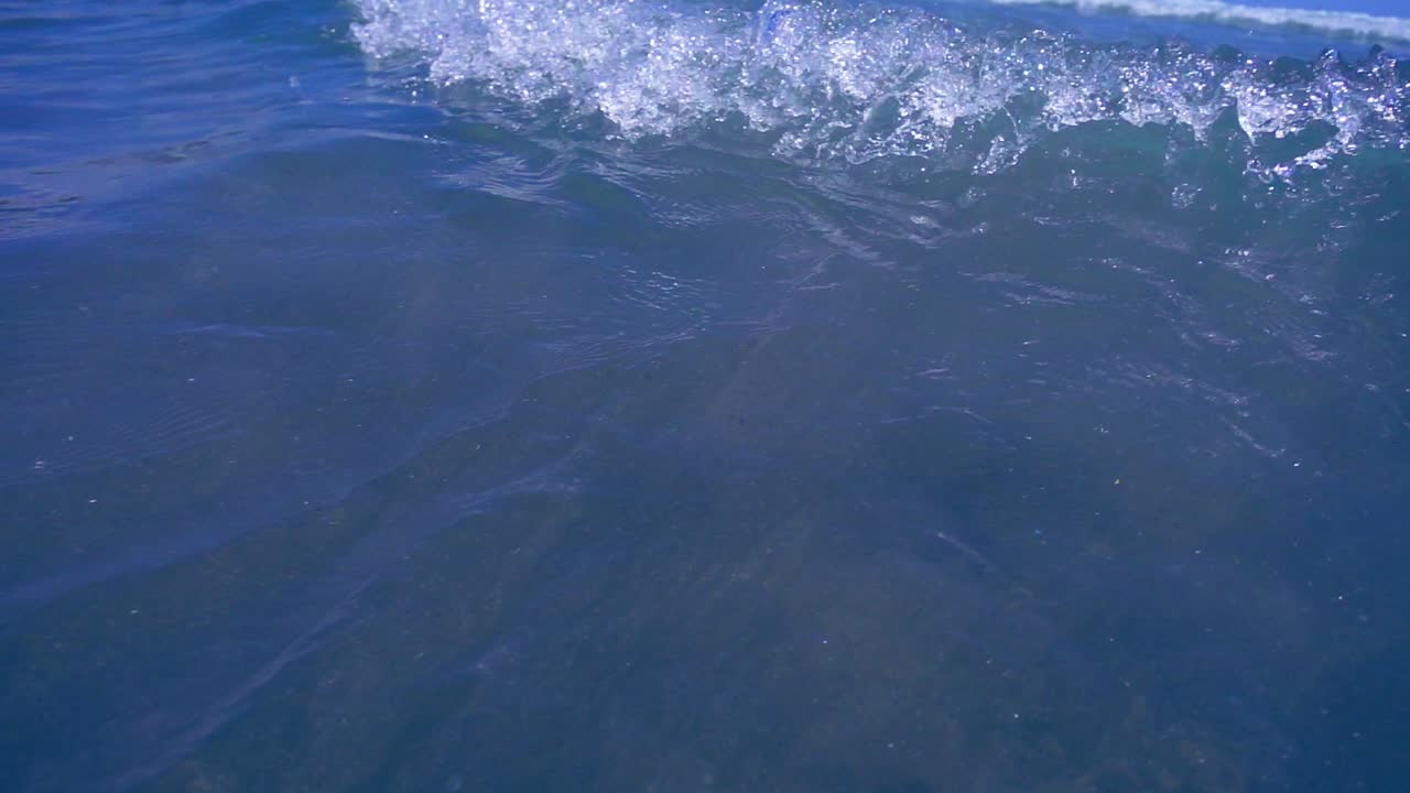 olas de espuma oceánica en la playa. movimiento lento de espuma de olas suaves en la plaga