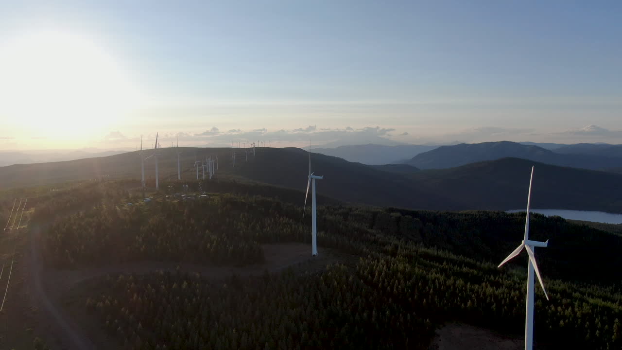 Grandi turbine eoliche che generano elettricità al tramonto.