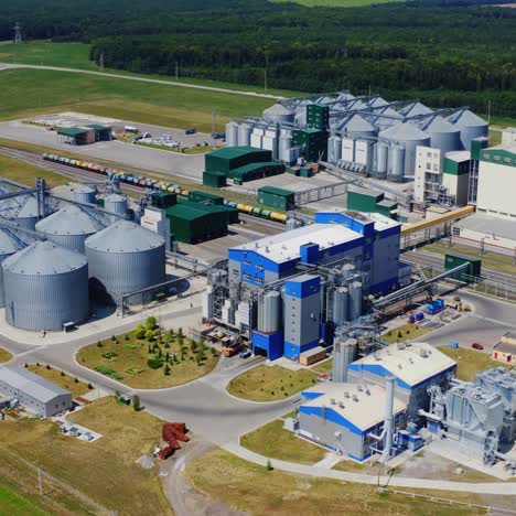 elevators among green nature. modern agricultural zone for grain storage. granary on field. steel tanks for storing cereals. aerial view.