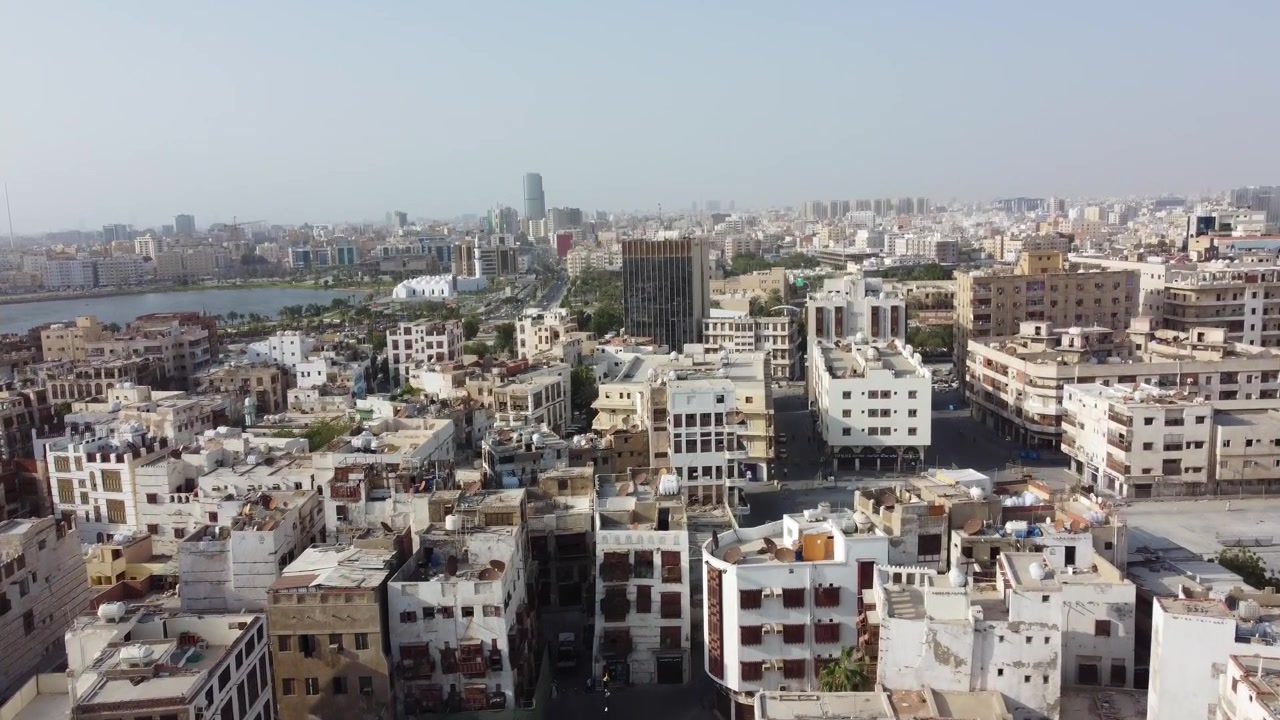 Ampia ripresa aerea panoramica di un denso paesaggio urbano con edifici residenziali tradizionali, tetti e architettura moderna sotto un cielo velato in un quartiere storico dell'Arabia Saudita