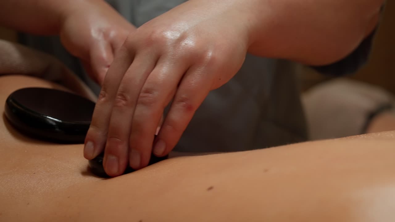 Nærbillede af hot stone massage på en persons ryg
