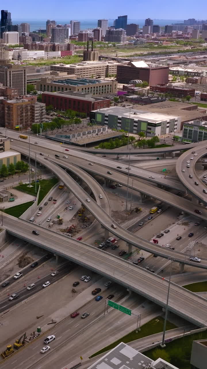 Intertwining roads of Chicago with busy traffic at daytime. Beautiful city panorama at backdrop. Vertical video