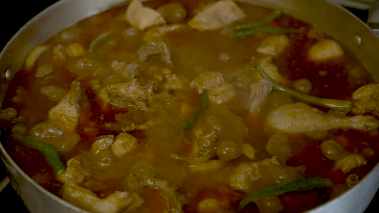 vista de cerca del burbujeante curry de pollo a fuego lento con chiles verdes frescos