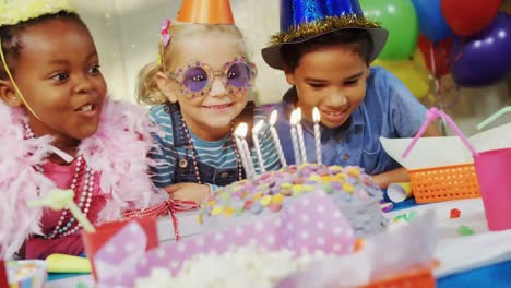 Animation-of-red-shapes-spinning-over-birthday-cake-and-children-having-fun-at-party