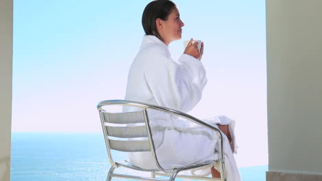 Woman-drinking-a-coffee-with-a-sea-view