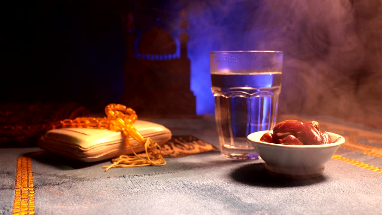 agua y dátiles. el iftar es la comida de la noche. vista deslizante de la decoración vacaciones de ramadán kareem. tarjeta de felicitación festiva, invitación para el mes sagrado musulmán ramadán kareem. fondo oscuro. enfoque selectivo