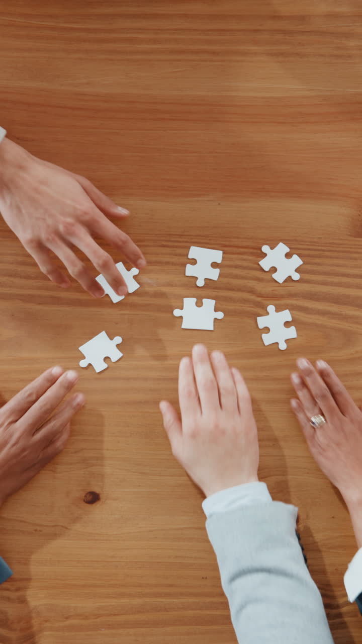 Mani che rimuovono pezzi bianchi di puzzle da un tavolo di legno