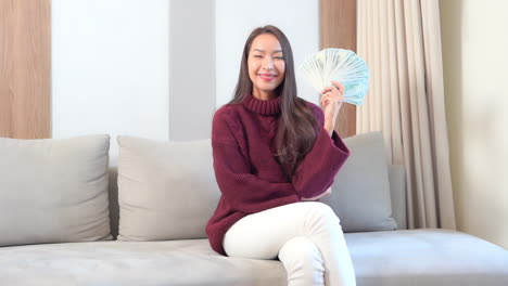 sexy exotic woman posing to camera with hand full of cash dollar money, lottery winning concept, full frame slow motion