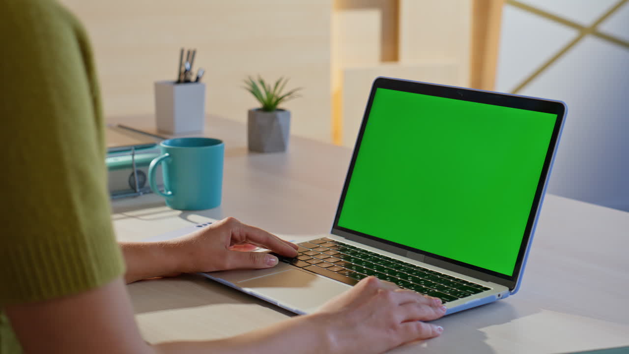 mujer trabajando en una computadora portátil con pantalla verde
