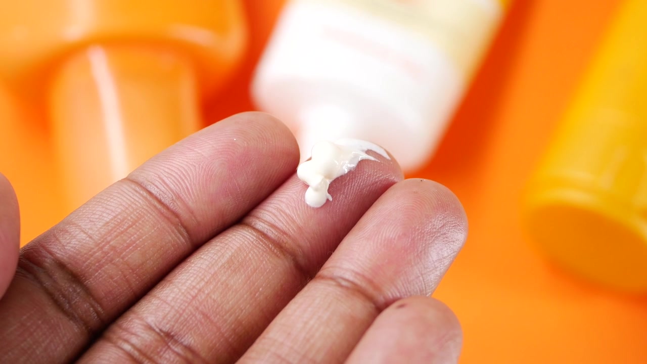 Close-up of a Finger with White Cream, Possibly Sunscreen or Lotion