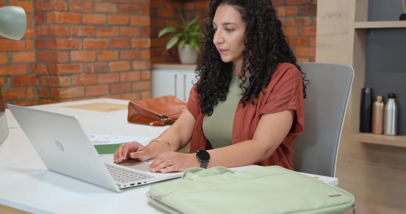 Donna Afroamericana che Apre una Custodia Verde alla Scrivania, Estraendo Laptop e Documenti, Iniziando a Lavorare
