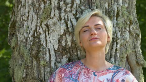 Eine-Frau,-Die-Allein-In-Der-Natur-Steht-Und-Ihren-Geist-Beruhigt,-Indem-Sie-In-Einem-Meditationsmoment-Die-Augen-Schließt