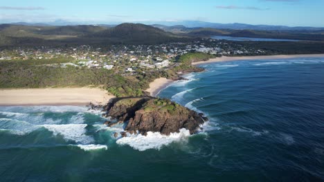olas espumosas del océano salpicando en norries head en nueva gales del sur, australia - retirada aérea