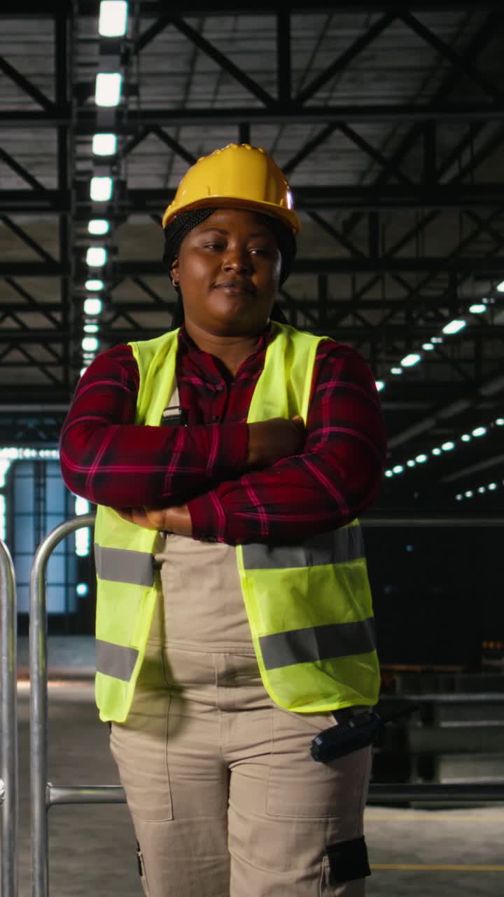 Vídeo Vertical Retrato, engenheira negra, galpão de máquinas, planta industrial.