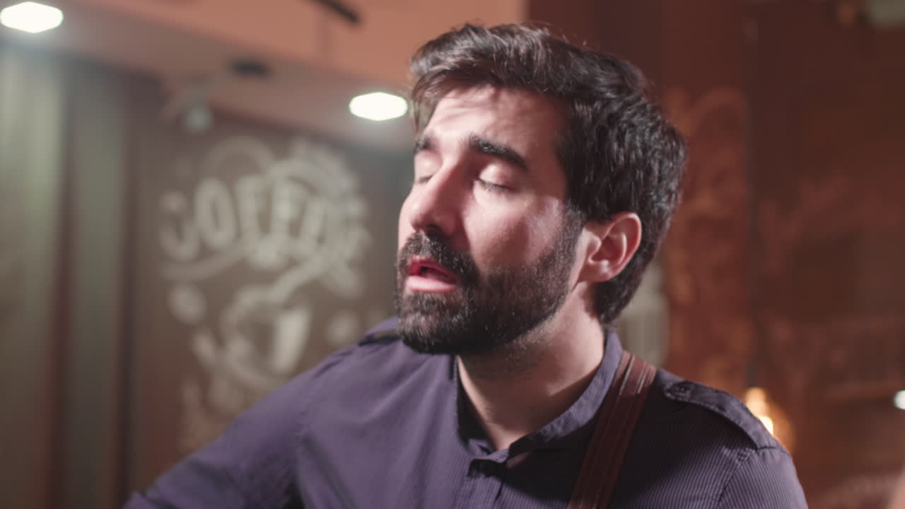 Man singing with guitar in a cafe