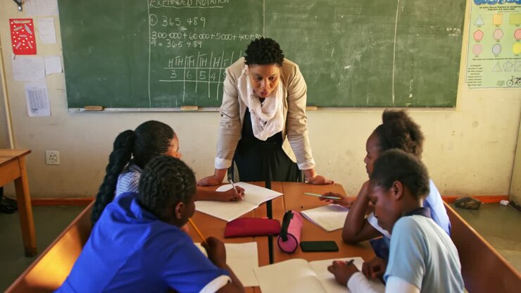 Female teacher and young pupils working in class 4k