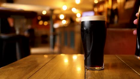 two pints of stout being picked up