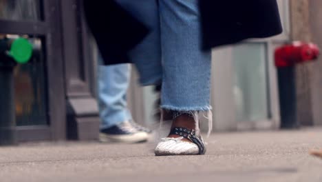 people walk on the street, close up to feet, shoes, boots, sneakers. day time, busy street. spring time.