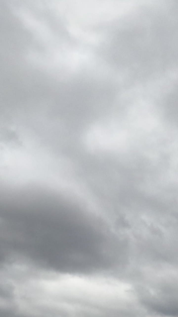 Rainy cloudscape formation in the sky at daytime. Gloomy weather horizon covered with clouds. Low angle view. Timelapse. Vertical video
