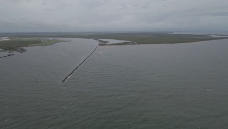 rompeolas en el río burnett con el parque de conservación de la isla barubbra - burnett heads, queensland, australia
