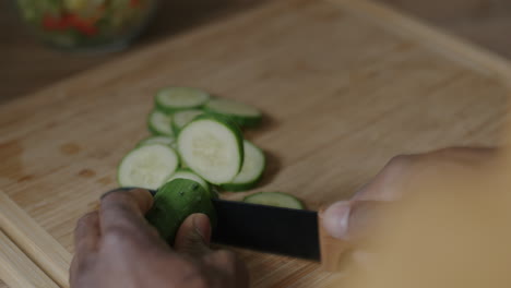 cortar pepinos en una tabla de cortar de madera