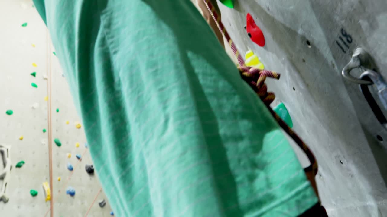 Men and woman practicing rock climbing in fitness studio 4k