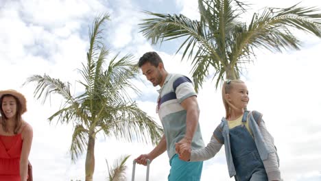 Glückliche-Kaukasische-Familie,-Die-Mit-Gepäck-Am-Strandhaus-Spaziert