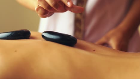 image of a woman getting massage with stones on her back