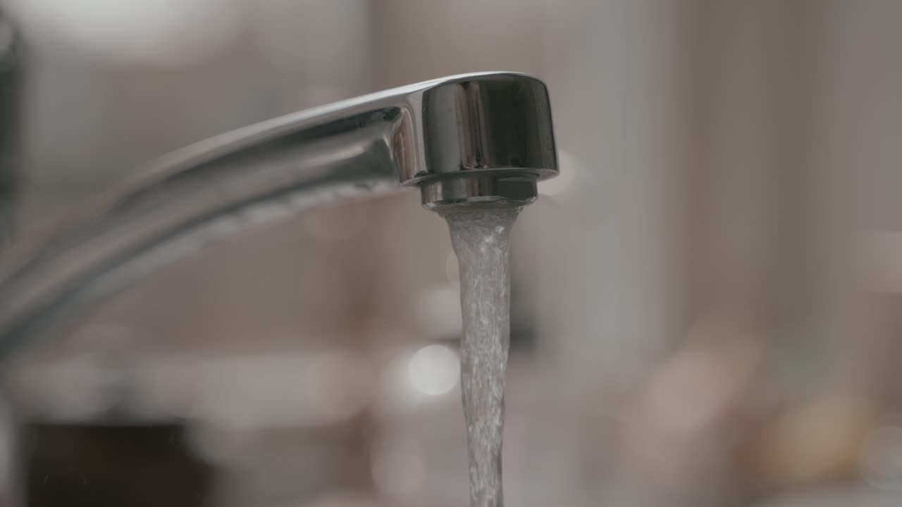 Agua fluyendo del grifo en cámara lenta.