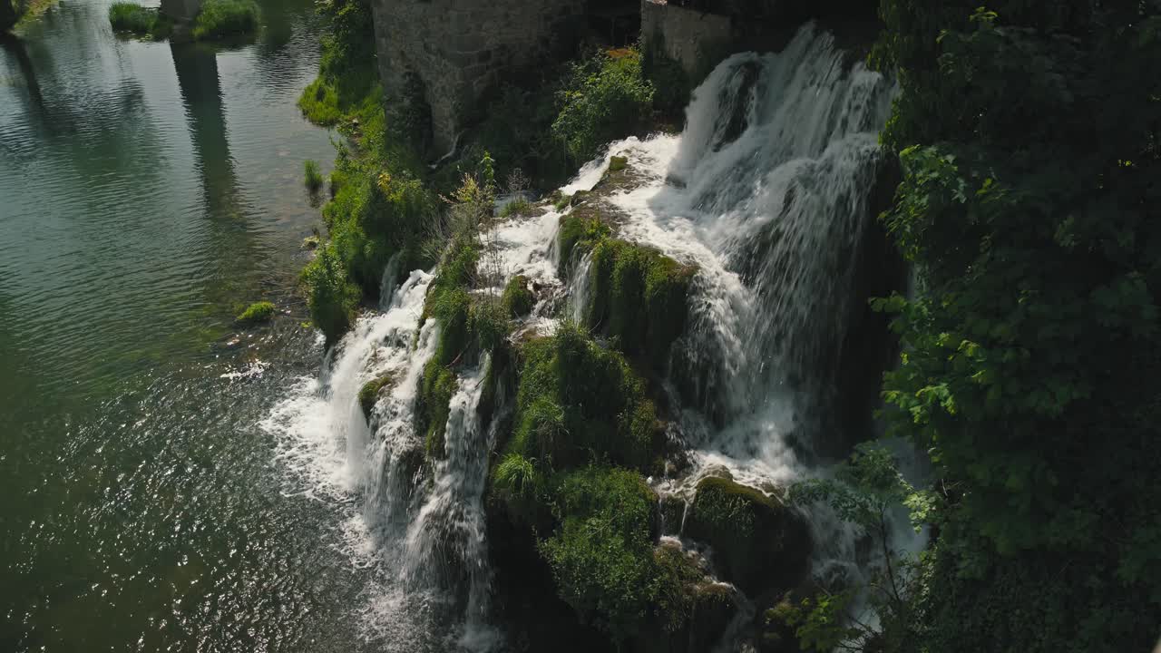 Pittoresca cascata che si getta in un fiume circondato da una vegetazione lussureggiante a Rastoke, Croazia.
