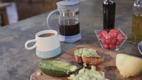 primer plano de sándwiches de aguacate, verduras y café en la cocina, cámara lenta