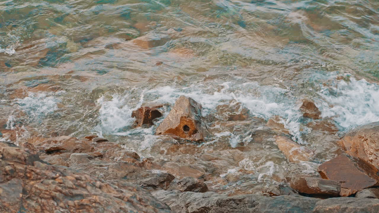 Clear Ocean Waves Crashing on Rocks at the Shoreline