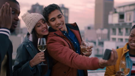 happy group of friends posing for selfie photo enjoying rooftop party celebration having fun drinking wine sharing weekend in city on social media