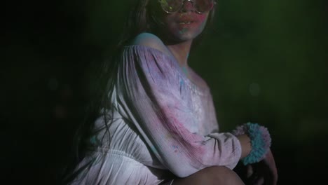 dancing young indian woman with dry color powder holi exploding around her