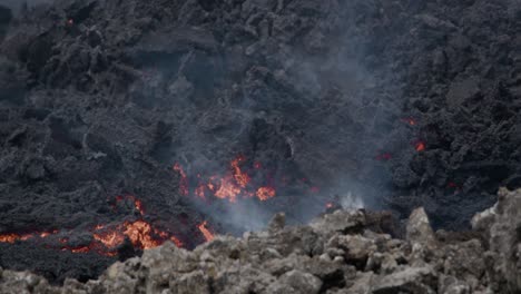 molten lava slowly flowing from grindavik volcano in sundhnúkur crater, iceland, with smoke rising